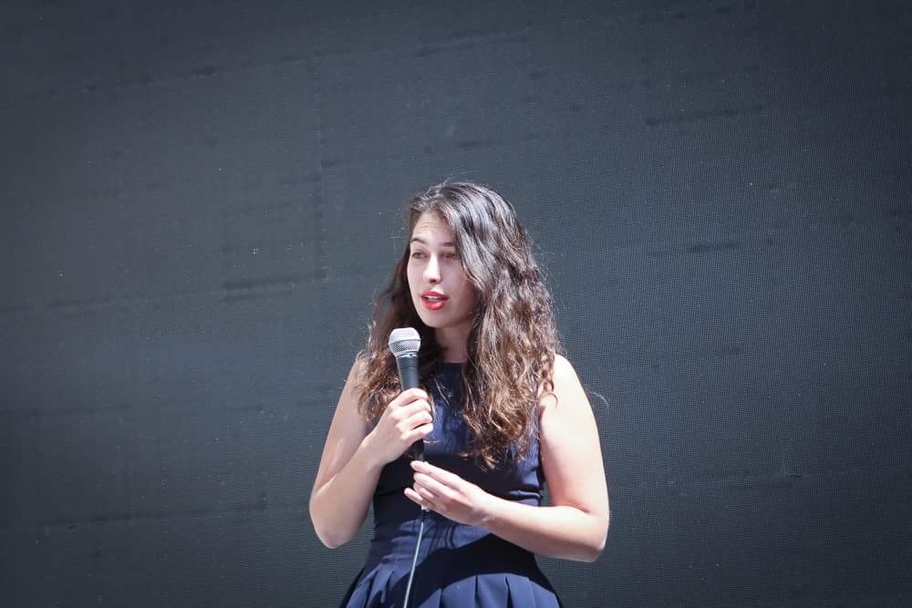 Helen Wexler speaking onstage with a microphone